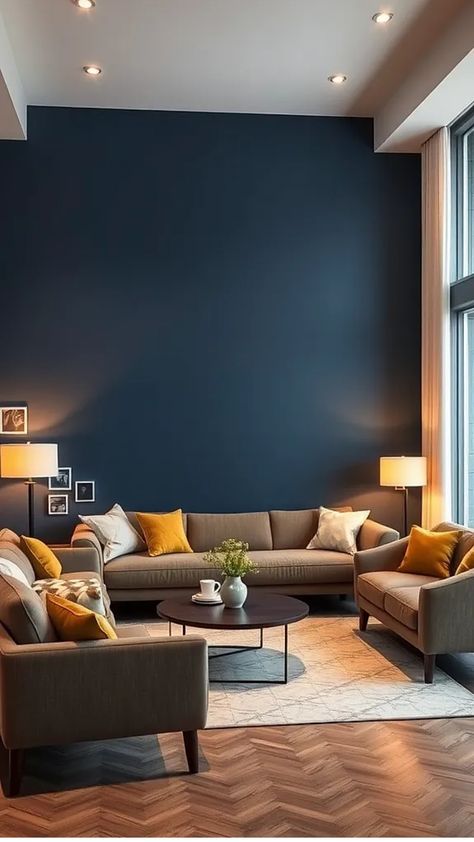 Modern living room with dark blue accent wall, brown sofas, yellow cushions, and a round coffee table. Blue Wall Black Furniture, Navy Blue Armchair Living Room, Living Room Decor Dark Blue, Living Room Decor Blue Walls, Blue Armchair Living Room, Dark Blue Living Room Color Scheme, Navy Living Room Ideas, Color Living Room Ideas, Blue Wall Decor Living Room