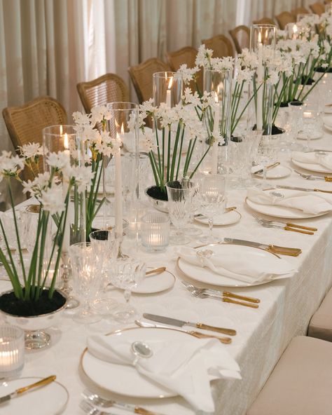 Elegant white wedding reception table setting with paperwhite flowers in crystal vases, gold flatware, and tall candle holders on crisp white linens Modern Minimalist Wedding Decor, Modern Minimalist Reception, Wedding Table Design, Luxury Wedding Reception, Minimalist Reception, Elegant Wedding Table, Naples Wedding, White Floral Centerpieces, Luxury Weddings Reception