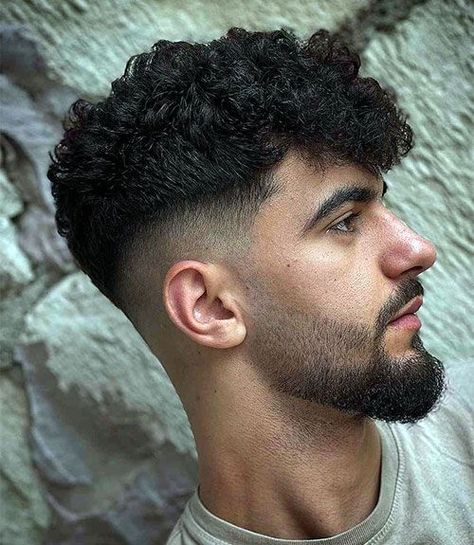 Thick Curls with Mid Fade and Beard. This cool men’s hairstyle pairs naturally well with a masculine beard to achieve a well-groomed, effortlessly attractive appearance. A stylish facial hair style can be a simple way to balance your dimension and haircut. Indian Hairstyles Men, Faded Beard Styles, Mens Short Curly Hairstyles, Mens Hairstyles Curly, Men's Curly Hairstyles, Curly Hair Fade, Mens Hairstyles Fade, Beard Fade, Medium Curly