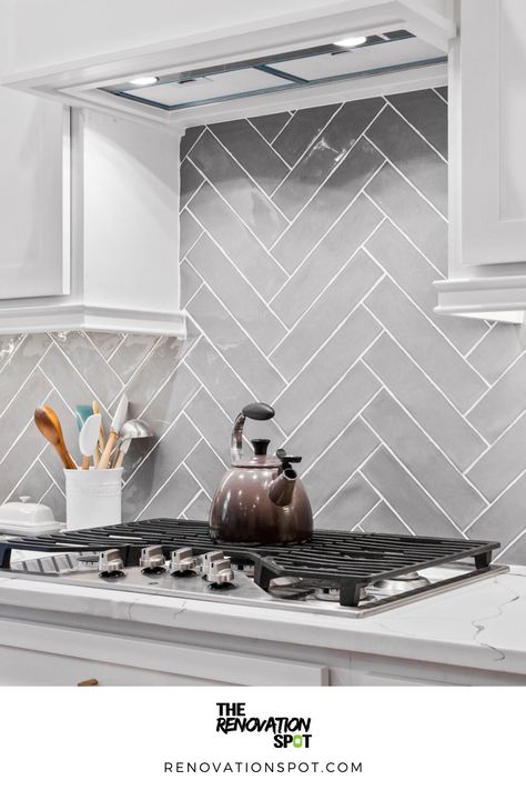 Kitchen Remodel by the Renovation Spot | Grey Herringbone Backsplash for White and Gold Kitchen Remodel | Modern Kitchen Design Modern Grey Kitchen Backsplash, Grey Herringbone Backsplash Kitchen, Kitchen Backsplash Grey And White, White Cabinets Gray Herringbone Backsplash Black Countertops, White And Grey Kitchen Backsplash Ideas, Kitchen Grey Tiles Wall, Dark Grey Herringbone Backsplash, Light Gray Herringbone Backsplash, Grey Chevron Backsplash