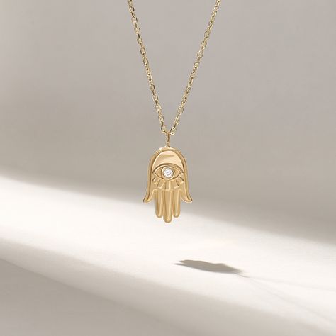 14k Solid Yellow Gold with 0.02 ctw Tiny Real Natural Diamond Minimalist Hamsa Hand Necklace is available from 14 to 18 inches long. The delicate and versatile design of this pendant makes it an ideal everyday accessory, suitable for any occasion. Its timeless beauty and spiritual significance make it a perfect gift for yourself or a loved one, symbolizing your wish for their well-being and prosperity.  Features  * Made to Order * Gold KT: 14KT  * Custom Gold Color: Yellow Gold  * Charm 9.90mm x 18.65mm  * Charm Thickness: 1.70mm  * Diamond Color-Clarity: D-E-F color VVS clarity (excellent ideal cut) * Total Ctw: 0.02 ctw * Ready to Ship in 5-7 Business Days ✓ We care about the environment,the jewelry we cast is made with recycled gold. We source exclusively post-consumer material that is Nazar Necklace, Hand Pendant, Hamsa Necklace, Hand Necklace, Luck Charm, Tiny Diamond, Luck Charms, Everyday Accessories, Hamsa Hand