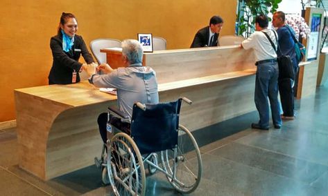 The reception area of the CapitaGreen building has a lowered front desk. The building has won numerous accessible design awards. Barrier Free Design, Hospital Reception, Front Desk Design, Reception Area Design, Accessibility Design, Desk For Office, Reception Desk Design, Office Aesthetic, Counter Desk