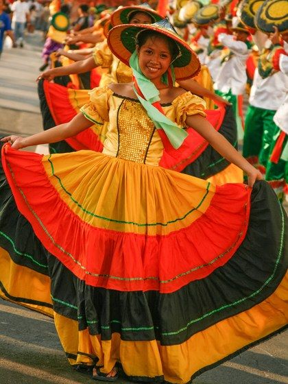 Philippine native dances and attire have over generations incorporated European, Latin American, and Asian influences. This Manileño festival costume bears a striking resemblance to the native dress of Andalusia, but bears Mexican-inspired colors and is topped by a traditional Filipino salakot hat. Columbian Traditional Clothing, Festival Dance Philippines, Folk Dance Costume Philippines, Festival Costumes In The Philippines, Sinulog Festival Costume, Learning Tagalog, Philippine Traditions, Philippine Festivals, Vintage Filipino