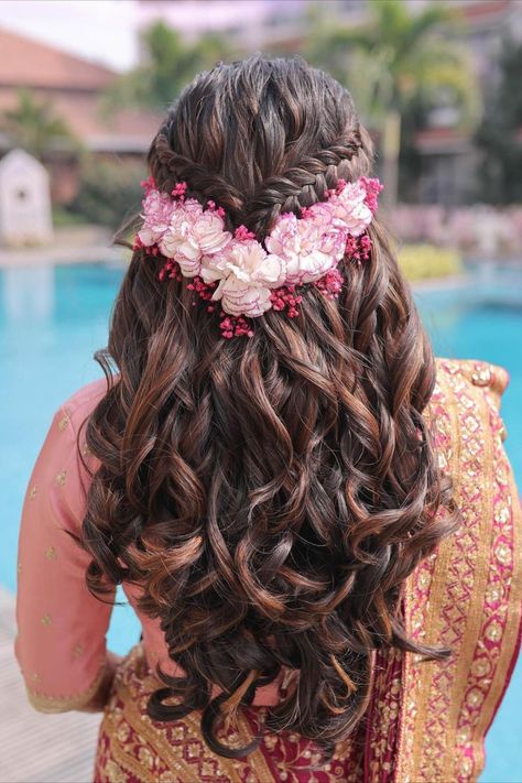 Channel your inner flower goddess with this ethereal bridal hairstyle! Cascading curls meet meticulously crafted braids, all adorned with the softest pink blooms. A Mehendi look can fall into the 'attention-worthy' category only when all these elements are well thought of - outfit, makeup, and hair. And with everything about experimentation, why to forget about the unique hairstyles that you can explore! Hair Style On Saree, Hair Colour Design, Half Updo Hairstyles, Hairstyles Design, Hair Style Vedio, Sophisticated Hairstyles, Engagement Hairstyles, Hair Color Underneath, Traditional Hairstyle