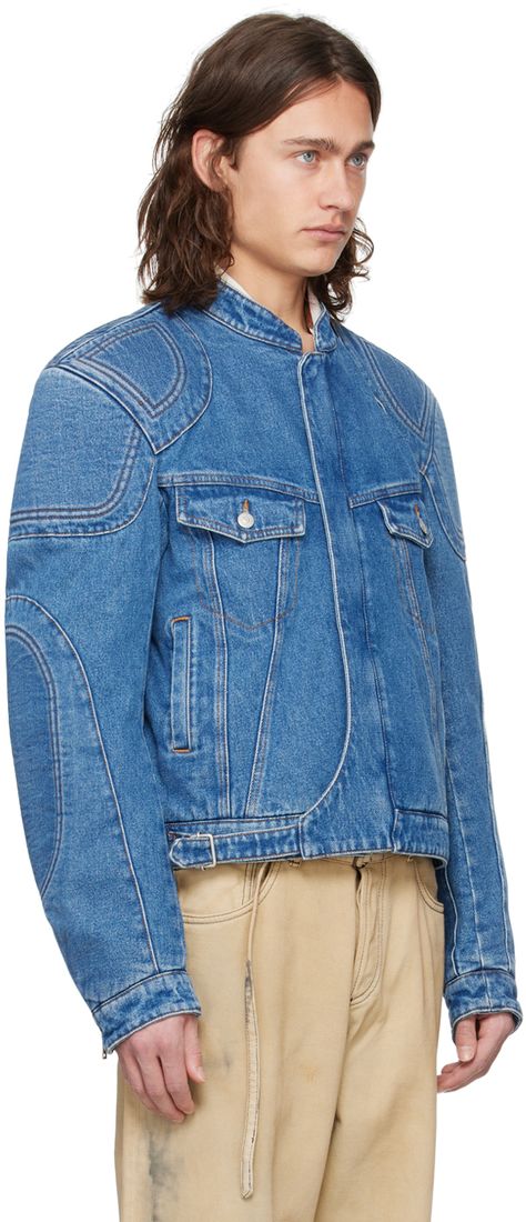 Non-stretch denim jacket. Fading and reinforced panels throughout. · Paneled construction · Band collar · Two-way zip closure with press-stud placket · Flap and zip pockets · Adjustable cinch strap at cropped hem · Padded shoulders and elbows · Zip vent at cuffs · Suede logo patch at back hem · Adjustable button tabs at back hem · Welt pocket at interior · Full twill lining · Contrast stitching in tan Supplier color: Mid blue Biker Denim Jacket, Futuristic Jacket, Denim Biker Jacket, Designer Denim Jacket, Mens Fashion Denim, Panel Jacket, Biker Denim, Denim Jacket Outfit, Denim Ideas