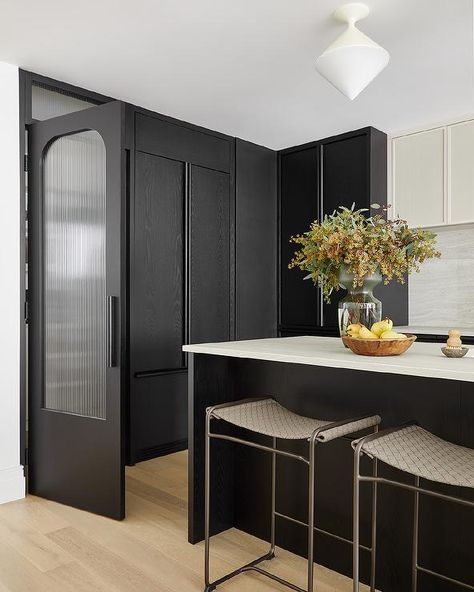 A hidden walk-in pantry is concealed behind a black door finished with a rippled glass panel. Walk In Pantry Design, Kitchen Door Designs, White French Doors, Wooden Pantry, Collective Studio, Steel French Doors, Glass Pantry Door, Light Gray Cabinets, Hidden Pantry