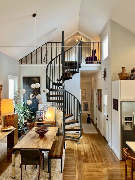 An open room with a spiral staircase leading upstairs and a long wooden dining table Sf Apartment, San Francisco Apartment, Vintage Apartment, House Smell Good, Vintage Credenza, Beautiful Sofas, House Smell, Casual Home, Loft Apartment