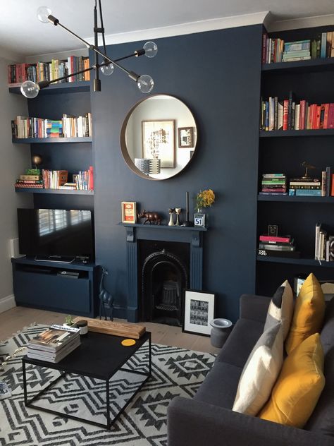 Dark blue living room. Styled dark using Farrow & Ball's Stiffkey Blue, accessorised with warm yellow accents. #farrowandball #stiffkeyblue #styleitdark #darkwalls #darkpaint #livingroomdesign #interiordesign #myhomevibe #londoninteriordesign #bookshelf #shelfstyling #blue #roundmirror #fireplace Abstract Interior, Dark Blue Living Room, Victorian Living Room, Dark Living Rooms, Sala Grande, Interior Paintings, Small Living Room Decor, Trendy Living Rooms, Blue Living Room