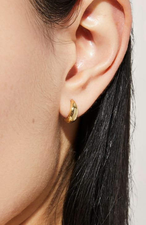 Business in the front, party on the sides—meet our bold huggie hoops. These hoops have a teardrop appearance when seen head-on due to its tapered top at the post; they’ll add a fun element of surprise to your everyday outfit. Their unique teardrop design is eye-catching yet minimalistic. Sleek gold huggie earrings Recycled Sterling silver finished in 14K gold Width: 10.93mm - 0.04" Depth: 2.15mm - 0.08" Weight: 0.82g Hoop Diameter: 10.93mm - 0.43” Post: 14K Gold On Sterling Silver Hinge Clasp Cr Cute Big Earrings, Gold Mini Hoop Earrings, Gold Earring Aesthetic, Gold Jewelry Simple Earrings, Earrings Aesthetic Gold, Gold Earrings Aesthetic, Unique Gold Earrings, Rising Aesthetic, Huggy Earrings