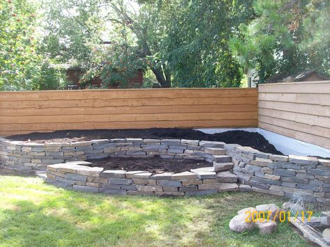 Another natural stone wall I built. I wasn't very particular about building up against a fence, but it still made for a nice two level garden. I always try to add in some stairs for a more interesting look. Easy access for working is important as well. visit www.dream-yard.com for landscaping how-to's, picture ideas, and articles. Privacy Fence Landscaping, Fence Planning, Landscaping Along Fence, Fence Boards, Backyard Privacy, Dream Yard, Walled Garden, Fence Landscaping, Have Inspiration