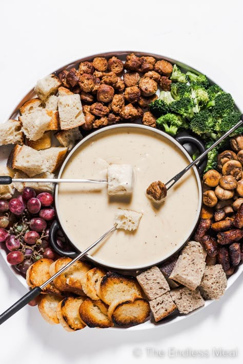 This cheese fondue is creamy, smooth, and by far the best! It's classic melted gruyère cheese flavored with caramelized shallots, apple brandy, and warm spices. It's an easy recipe that's perfect for seasonal gatherings, and it's ready in just 35 minutes! #theendlessmeal #fondue #cheesefondue #nye #cewyearseve #appetizer Cheese Fondue Platter, Cheese Fondue Board, Christmas Fondue Party Ideas, Vegetarian Fondue, Fondue Cheese Recipe, Fondue Charcuterie Board, Meat Fondue Recipes, Fall Fondue, Fondue Party Ideas