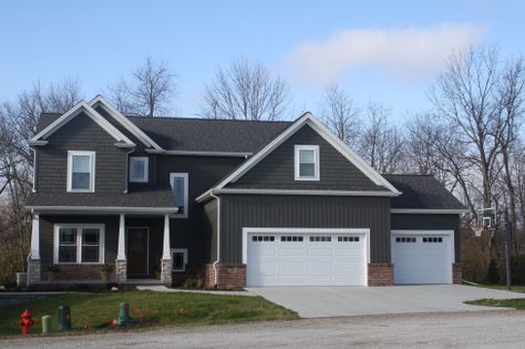 mastic-misty-shadow-dark-siding-dark-shakes-dark-board-and-batten-white-trim-white-carage-door-certainteed-landmark-driftwood-roofing-in-downs-il Dark Grey Siding, Certainteed Vinyl Siding, Mastic Siding, Vertical Vinyl Siding, Grey Vinyl Siding, Vinyl Siding House, White Garage Doors, Vinyl Siding Colors, Green Siding