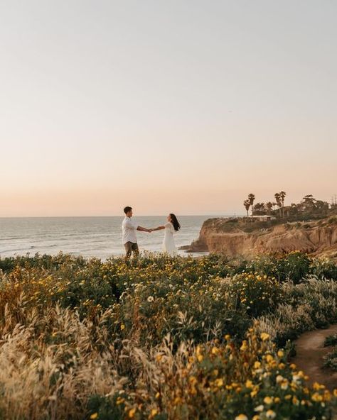 San Diego Wedding + Elopement Photographer | Natasha on Instagram: "If you wanna twirl in a wild flower field lmk 🌼 (& we’ll stay on marked paths bc nature restoration is sexiiii)   I visit this cliff side at least twice a week to declutter my mind. I love that I get to share this freeing space with so many others 💞 J+P opted for sunny SoCal for their engagement session and wow was magic made that night! Also shoutout to a surprise ending bc who knew you could see the rocket launch from LA??? 🚀  #sandiegoweddingphotographer #sandiegophotographer #socalphotographer #sandiegoengagement #sandiegoproposal  #westcoastphotographer #socalweddingphotographer #sdweddingphotographer #palmspringswedding #sandiegowedding #socalwedding #laweddingphotographer #ocweddingphotographer #losangeleswedding Sunset Cliffs San Diego Elopement, Sunset Cliffs Couple Photos, Sunset Cliffs Engagement Photos, Cliff Proposal, Cliff Photoshoot, San Diego Photoshoot, Wild Flower Field, Balboa Park Wedding, Sunset Cliffs San Diego