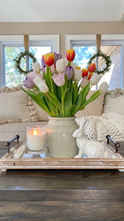 Tulips styled in a crock on a tray with a white ceramic bunny and a candle on the coffee table in front of the sofa with windows behind it. Spring Decor Dining Room Table, Tulip Centerpiece Easter, Spring Decor Bathroom, Spring Time Decorations, Cute Spring Decor, Spring Summer Living Room Decor, Home Spring Decor, Spring Modern Decor, Indoor Spring Decor