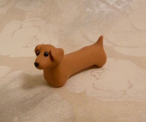 Doxie Desserts: This dachshund is handmade with FIMO and sold by GraceAndFlowers on Etsy. This simple shape could easily be recreated with fondant for use as a cake topper. Clay Sausage Dog, Weiner Dog Clay, Polymer Clay Sausage Dog, How To Make A Clay Dog Easy, Clay Weiner Dog, How To Make A Dog Out Of Clay, Dachshund Clay Sculpture, Polymer Clay Dachshund, Cute Clay Dog