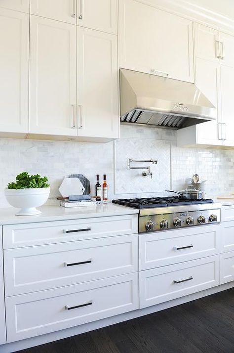 Mini brick marble backsplash graces a gorgeous white kitchen with a stainless steel upgrades, swivel pot filler, and traditional steel vent hood. Gorgeous White Kitchen, Model Dapur, Upper Kitchen Cabinets, Kabinet Dapur, Transitional Cabinets, Kitchen Cabinets Decor, Marble Backsplash, New Kitchen Cabinets, White Kitchen Design