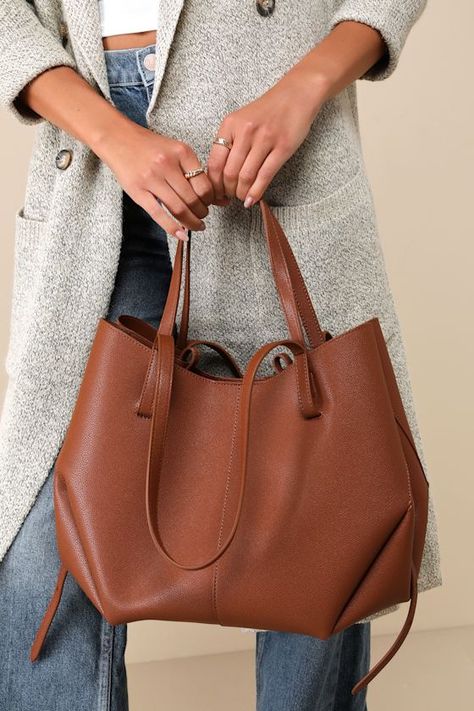 The Lulus Absolutely Quintessential Brown Vegan Leather Tote Bag is perfect for packing everything you need for a memorable getaway! This spacious tote has a pebbled, vegan leather construction that shapes a flat bottom design with two sets of top handles in small and large sizes. Undo the magnetic button closure at the center to reveal a super roomy interior with a bonus zipper pouch that secures at the side with a detachable strap. Magnetic closures at each side add a little extra security, wh Brown Leather Shopping Bag, Everyday Leather Tote Bag, Brown Tote Bag Outfit, Everyday Purse Casual, Leather Office Bags, Vietnam Clothes, Structured Tote Bag, Best Work Bag, Handmade Leather Tote Bag