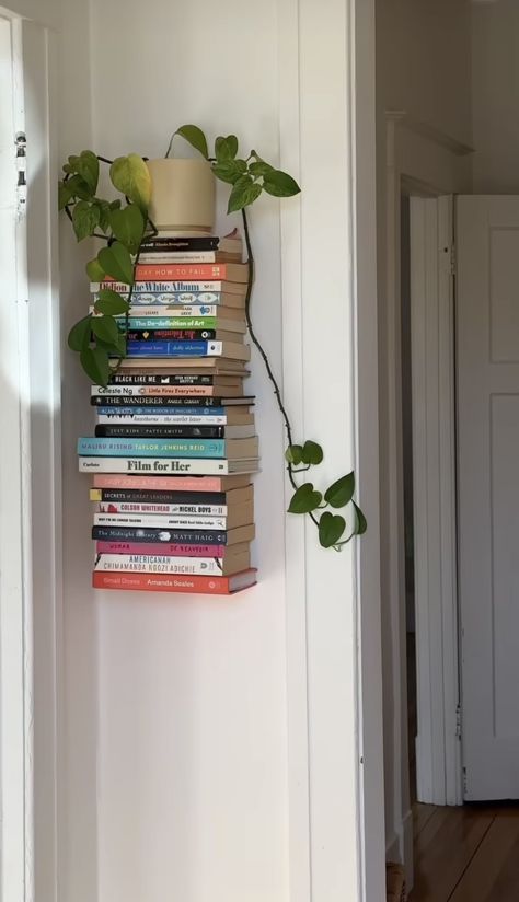 Books Around Door, Shelf In Front Of Window Living Room, Book Shelf Above Door, Book Stack On Floor, Bookcase With Plants, Book And Plant Shelf, Bookshelf Apartment Ideas, Bookshelf Above Door, Apartment Book Storage