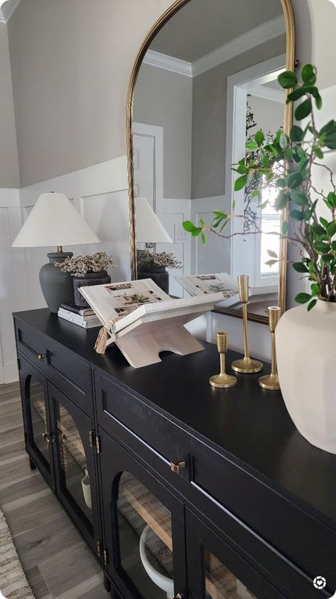 Entryway With Gold Mirror, Black And Gold Rustic Decor, Black Console Table Dining Room, Arched Entryway Mirror, Black Entry Console, How To Style A Entryway Table, Black And Gold Entryway Decor, Black And Gold Entrance Decor, Black Console Cabinet