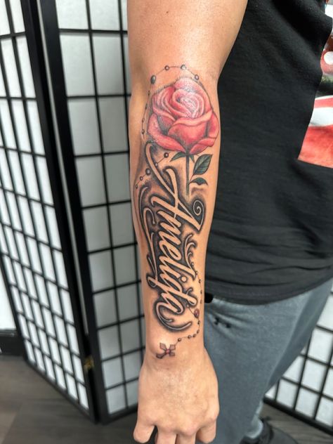 Name with rose and rosary Name With Rosary Tattoo, Name Tattoos With Rose, Tattoo With Siblings Names, Name With Roses Tattoo, Rose Rosary Tattoo, Moms Name Tattoo Ideas Men, Mom Name Tattoo For Men, Name With Rose Tattoo, Rose And Name Tattoo