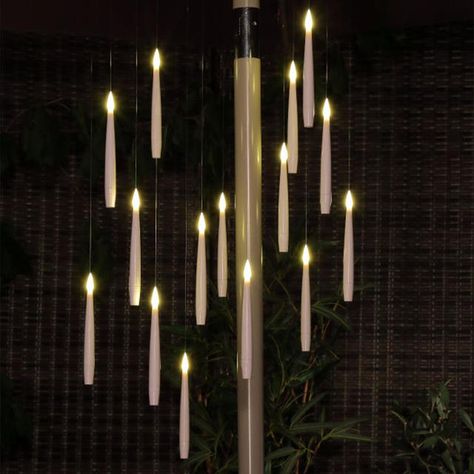 With a nod to the floating candles at Hogwarts, this delightful LED magic candle chandelier is a perfect way to add extra light and sparkle to your outdoor space or even hang under your parasol. With the effect they are almost floating, these battery LED candles are suspended from a circular wire and then hang from clear fishing wire. #lighting #outdoor lighting ideas; lights for parasol; sun umbrella lights; candle shaped lights. Floating Candles Chandelier, Hanging Candle Lights Wedding, Ceiling Floating Candles, Outdoor Christmas Chandelier, Candle Hanging Ideas, Witch Chandelier, Led Candles Decor Ideas, Esoteric Science, Chandelier Outdoor