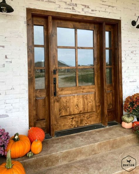 Rustica | Custom Doors + More on Instagram: “This doorway is giving us the perfect fall vibes! 🍂 Have you decorated your front porch yet? . . . #frontdoor #frontdoorinspo #porchgoals…” Knotty Alder Front Door With Sidelights, Modern Farmhouse Fiberglass Front Door, Rustic Front Door With Sidelights, Country Doors Farmhouse, Extra Wide Front Door Entrance, Stunning Front Doors, Coastal Farmhouse Front Door, Barndominium Front Doors, Rustic Modern Front Door