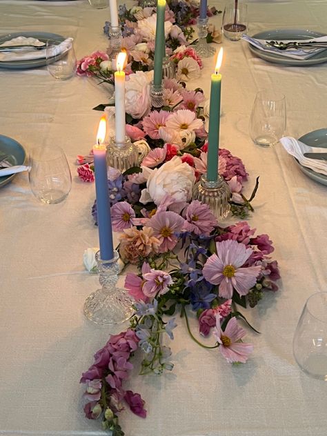 Pink purple blue pastel flower arrangement on dining table with candle sticks and blue ceramic dinner set for birthday dinner party Floral Party Table Decor, Flower Aesthetic Birthday Party, Maximalist Table Decor, Flower Themed Party Aesthetic, Circle Table Set Up, Flowers Laying On Table, Floral Dinner Table Setting, Wildflower Dinner Party, Flower Dinner Party Aesthetic