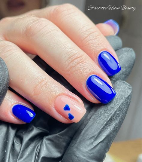 Gorgeous stand out blue with heart accents Blue Nails With A Heart, Sweethearts Nails, Simple Blue Heart Nails, Blue Nails Heart Design, Royal Blue Nails With Hearts, Valentines Day Nails Blue, Short White Nails With Blue Heart, Bright Blue Nails With Design, Blue Nails With Heart