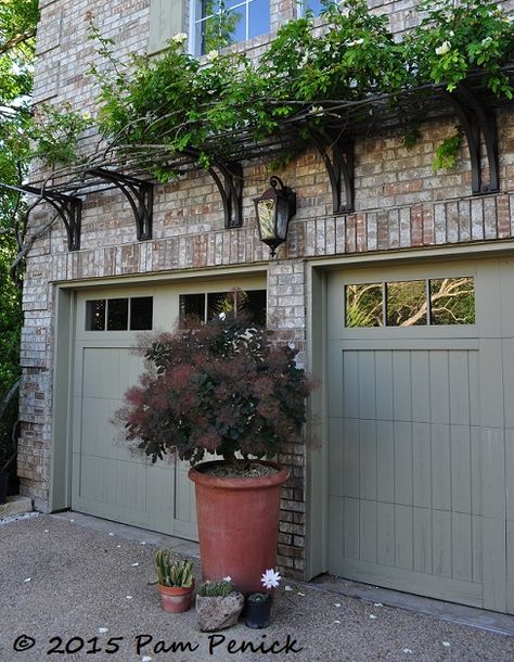 West Texas meets the Big Easy in the courtyard garden of Curt Arnette | Digging. Trellis over garage doors Vine Over Garage, Metal Trellis Over Garage Door, Front Entryway Garden Ideas, Garage Door Trellis Ideas, Trellis On Brick House, Garage Eyebrow Pergola, Window Trellis Exterior, Garage Trellis Ideas, Arbor Over Garage Door