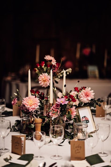 Bud vases full of pink and red wedding flowers and white taper candles for the centrepieces Red White And Black Wedding Decorations, Burgundy Bud Vase Centerpiece, Bud Vase And Candle Centerpiece Wedding Round Table, Dark Rustic Wedding Decor, White Round Table Wedding, Moody Bud Vases, Pink Rustic Wedding Decor, Candle And Bud Vase Centerpiece, Wedding Round Table Flowers