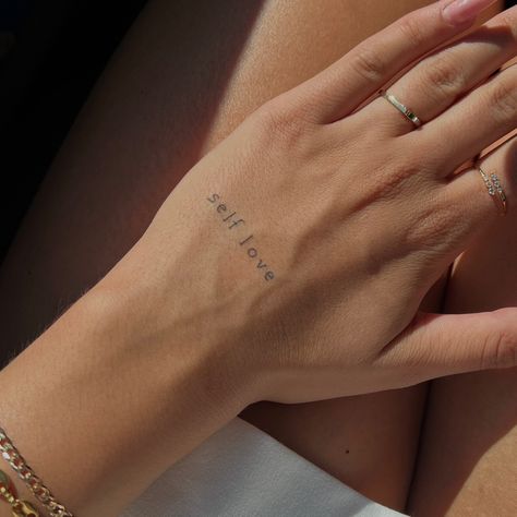 Small Hand And Finger Tattoos For Women, Hand Tattoos For Women Quotes, Small Self Love Quote Tattoos, Single Word Hand Tattoos, Tattoo Writing On Hand, Dainty Hand Tattoos For Women Words, Small Word Hand Tattoos For Women, Self Love Words Tattoo, Hand Quote Tattoos For Women