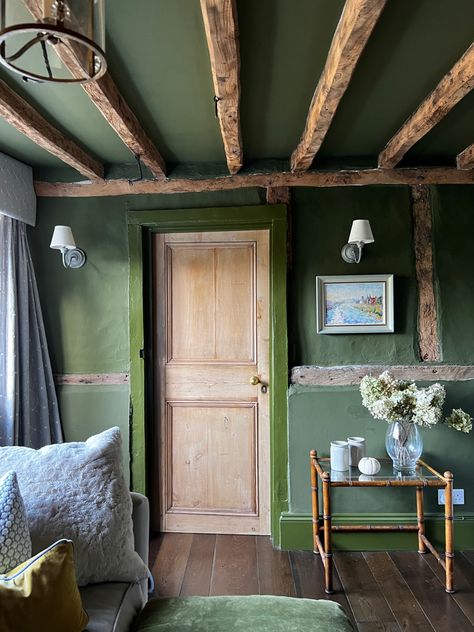 This 1610 original kitchen has been reimagined as s Snug/TV Room. The refurbishment involved gently blasting the beams with micro beads, installing wide oak floorboards and painting the walls and ceiling in @farrowball Bancha. Green Painted Rooms Bedrooms, Low Painted Ceiling, Low Ceiling Cottage Interior, Painted Beams Cottage, Green Ceiling Living Room, Light Green Ceiling, Green Walls And Ceiling, Wood Walls And Ceiling, Painted Ceiling Beams