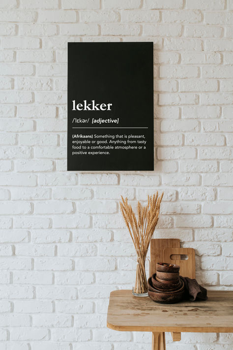 What does lekker mean? Lekker definition, meaning of lekker, pronunciation of lekker. Something that is pleasant, enjoyable or good. Anything from tasty food to a comfortable atmosphere or a positive experience. Minimalist dictionary style wall art for kitchen or dining room, south african culture, south african slang, proudly south african, lekker man, afrikaans sayings, south african sayings, african words, south african expat, born in south africa, #lagunaklein #lekker #southafrica South African Decor Ideas, Afrikaans Aesthetic, South African Aesthetic, Dictionary Aesthetic, African Sayings, South African Quote, South Africa Quotes, South African Decor, South African Culture