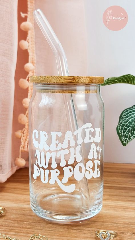 With its unique vinyl design featuring the quote "Created With A Purpose", it is sure to add that extra touch to your morning routine, hanging out with friends, or going about your daily tasks. The included bamboo lid and glass straw allow this glass to be eye-catching yet functional. Tumblers With Quotes, Christian Glass Cups, Cricut Glass Cup Ideas Vinyls, Aesthetic Soda Can, Glass Cups With Vinyl Cute Ideas, Glass Cup Design Ideas, Cups With Vinyl Cute Ideas, Christian Cups, Purpose Aesthetic