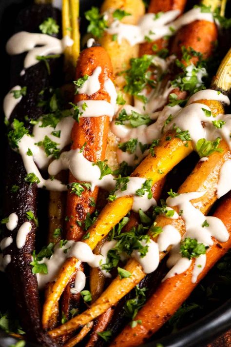 Colorful carrots roasted with spices and topped with a tahini and lemon dressing. Perfect side dish for Thanksgiving to Easter. Gluten free. rnrn#sidedishideas #peelwithzeal peelwithzeal.com Easter Gluten Free, Rainbow Carrot Recipes, Carrots Roasted, Caramelized Carrots, Gluten Free Recipes Side Dishes, Easy Side Dishes, Roasted Rainbow Carrots, Colorful Carrots, Lemon Tahini Dressing