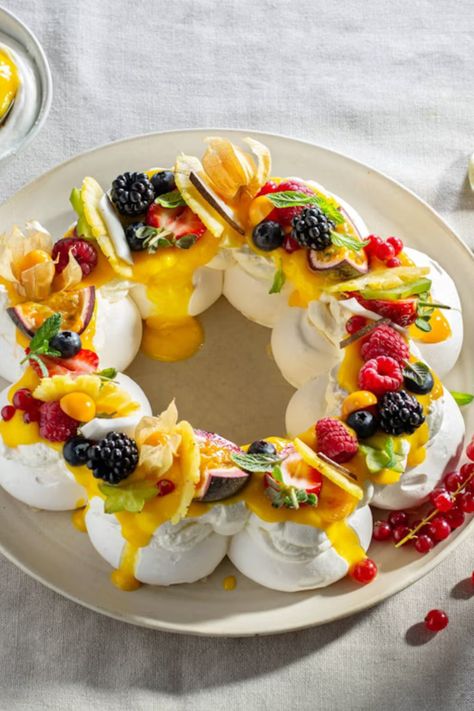 Tropical Pavlova is a light and airy dessert that is perfect for warm weather. The crisp meringue shell is filled with a fluffy coconut cream and topped with a colorful assortment of fresh tropical fruits. Deserts With Passion Fruit, Passion Fruit Trifle, Tropical Pavlova, Tropical Fruit Pavlova, Passion Fruit Tartlet, Pavlova Tropical, Christmas Buffet, Tropical Fruits, Passion Fruit