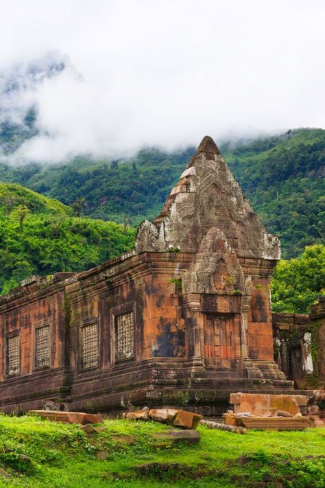 This is a 12th-century Hindu temple with a similar architecture as Angkor of Cambodia. Set against the breathtaking natural backdrop, Vat Phou is in Champasak, a UNESCO World Heritage Site in southern Laos. This temple currently serves as a Buddhist site. Laos offers incredible serenity with the beautiful Buddhist sites, untamed natural beauty and also the fact that it is so cheap you would love to visit again. Here are our top five things to do in Laos. Champasak, Types Of Architecture, Ancient Greek Architecture, Asian Architecture, Landlocked Country, Vientiane, European Architecture, Luang Prabang, Summer Destinations