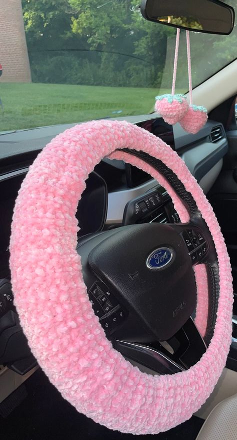 This is a Handmade Crochet Car Set. It has two seat belt covers, a mirror hanging strawberry and a steering wheel cover. The material is so soft and comfy. It is super cute and very appealing to the eye. Knitted Car Accessories, Crochet Sterling Wheel Cover, Crochet Car Stuff, Steering Wheel Crochet Cover, Coquette Car Decor, Crochet Car Wheel Cover, Car Seat Crochet, Crochet For Car, Car Crochet Accessories