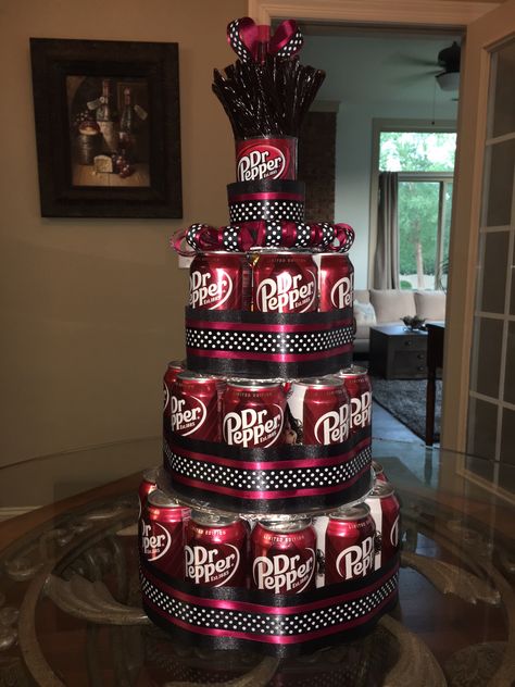 Dr Pepper can cake with Dr Pepper Twizzler "candles" on top.  "Cake" is stuffed full of bags of Cheez-Its.  It took 2 cases (24 cans) to build and 1 bottle that I cut the top off above the label to put the Twizzlers in.  Each layer is sitting on a cardboard circle wrapped in foil. I wrapped it in layers of ribbon and added ribbon loops on the top layer. Soda Can Cakes, Birthday Gifts For Boss, Dr Pepper Cake, Boss Birthday Gift, Soda Cake, Cake In A Can, Beer Cake, Dr Pepper Can, Candy Cakes