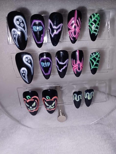 "\"Neon Frights\" full set of press on nails. Includes 14 nails in 7 sizes. These fun, neon light-inspired nails are perfect for Halloween! Done on a black background and featuring spooky images in vibrant colors! Black Light Reactive! Can be done in your custom sizes, shape and length! Includes nail glue, file, cuticle stick, alcohol wipes and instruction sheet!" Neon Nails Halloween, Neon Lights Nails, Modern Halloween Nails, Glowing Halloween Nails, Black And Neon Pink Nails, Neon Light Nails, Black Light Nails, Glow In The Dark Halloween Nails Short, Neon Goth Nails