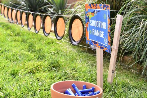 Paper plate "shooting range" on stakes in the ground; party shirts Boy 11th Birthday Party Ideas, Hunting Theme Party Games, Silly String Games, 8th Birthday Boy, Nerf Themed Birthday Party, Police Themed Birthday Party Kids Games, Indoor Nerf Party, Nerf Party Table, Nerf Party Backdrop