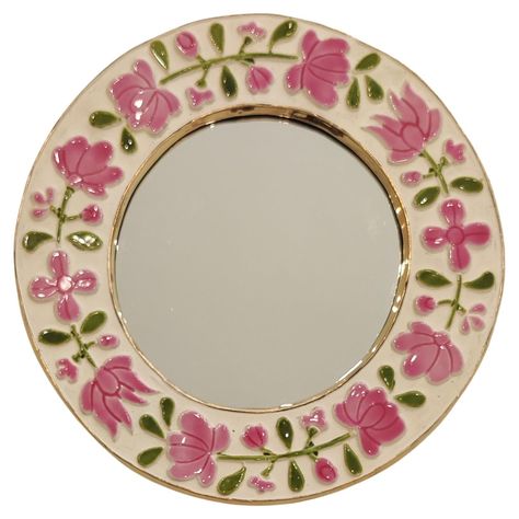 This beautiful colored mirror, whose discreet irregularity is its charm, is one of the variations described as "romantic", produced in the mid-1960s. Decorated with delicate pink and green floral motifs on a white background, the enamel reveals a light preciosity and unparalleled gaiety. How is Mithé Espelt? Marie-Thérèse Espelt, better known as Mithé Espelt, was born in 1923 in Lunel in the Camargue region of southern France. She grew up surrounded by the exceptional social circle of her grandf Cute Mirror Wall Decor, Light Pink Aesthetic Room Decor, Flowers Painted On Mirror, Pink And Green Room Decor, Mirror Painting Ideas Art, Aesthetic Mirror Decor, Decorate Mirror, Round Mirror Frame, Green Room Decor