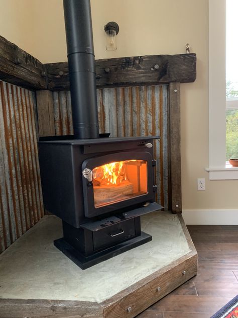 Wood Stove Tin Surround, Corrugated Metal Wood Stove Surround, Rustic Wood Burning Stove, Wood Stove Room Ideas, Rustic Hearth Ideas, Shed Fireplace, Wood Stove Metal Surround, Woodstove Surrounds Metal, Corner Wood Stove Mantel Ideas