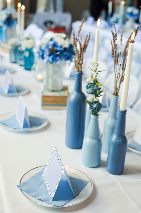 DIY wedding: Spray paint old bottles in multiple shades of a color. Add flowers and candles. Shades Of Blue Centerpieces, Shades Of Blue Bridal Shower Ideas, Mama Mia Inspired Wedding, Diy Mamma Mia Decor, Wine Bottle Wedding Decor, Decoration Communion, Candles And Flowers, Early Spring Wedding, Flowers And Candles