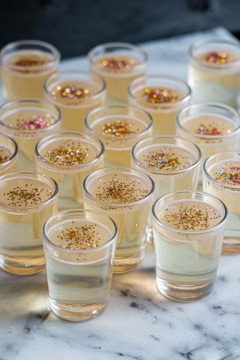 A photo of a  Glitter Champagne Prosecco Jello Shots a New Years Champagne Jello Shots Jello Shots New Years Eve, New Years Shots Ideas, Prosecco Jello Shots, Nye Shot Recipes, New Years Jello Shots, New Years Shots, Nye Mocktails, New Year’s Eve Drinks, Jello Shots Non Alcoholic