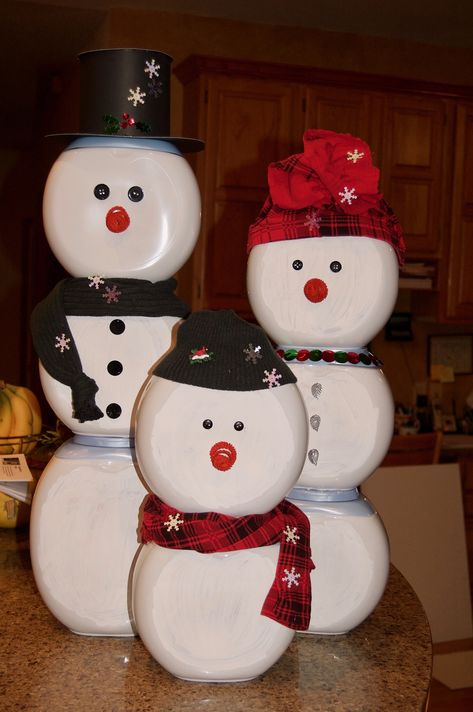 This snowman family was made from white Tide Pod containers and decorated with stuff from around the house! An old pair of leggings was cut up to make the red hat and scarf. An old sweater made the dark green hat and scarf. Buttons for eyes, coiled pipecleaners for noses, poster board for the top hat, and sequins to add some bling. These will decorate my husband's office for a holiday contest; his theme is 'Reduce - Reuse - Regift'. :) Recycle Tide Pod Containers, Upcycle Laundry Pod Containers, Crafts With Pod Containers, Tide Pods Container Crafts Diy, Tide Pod Christmas Craft, Tide Pod Containers Crafts, Gain Container Crafts, Snowman Tide Pod Container, Tide Pod Snowman