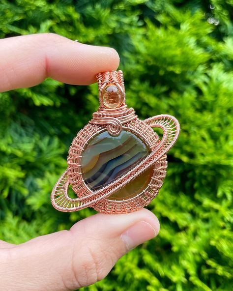 Just a little sneak peek at one of my favorite celestial pieces coming to the shop this week! 🪐 The colors & dimension in the Brazilian agate are so beautiful. I paired it with a citrine stone & wrapped it in copper wire! 🧡 • • • #wirewrap #wirewrappedjewelry #handmadejewelry #celestialjewelry #wirewrappedcrystals #planet #saturn #astrologyjewelry #astronomy #astrology #saturnreturn #agate #citrine #wireweaving Saturn Wire Wrap, Wire Wrapped Sun Pendant, Wire Wrapped Agate Slice, Wire Wrapped Agate Pendant Necklace, Saturn Return, Spiritual Agate Wire Wrapped Necklaces, Astrology Jewelry, Brazilian Agate, Stone Wrapping