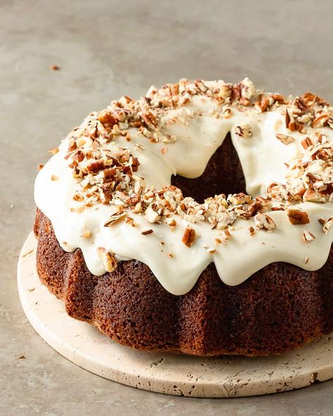 Carrot bundt cake is a perfectly moist carrot cake filled with freshly grated carrots and a blend of classic warming spices. Top this bundt carrot cake with a rich and tangy cream cheese glaze and crunchy pecans. With its beautiful bakery worthy appearance and easy preparation, this carrot cake bundt cake is the perfect cake for all your holiday gatherings. Hummingbird Bundt Cake, Bundt Pan Recipes, Pumpkin Pound Cake, Apple Bundt Cake, Butter Pecan Cake, Moist Carrot Cakes, Chocolate Bundt, Hummingbird Cake, Butter Icing