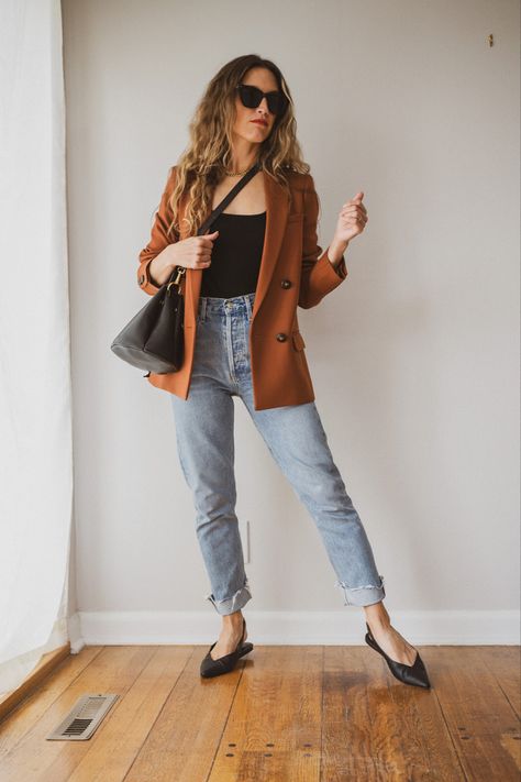 Ashley wearing a black tank under a rust colored blazer, light Wash straight jeans cuffed, black slingback flats, black cat eye sunglasses, and a black bucket bag Rust Jeans Outfit, Rust Brown Sweater Outfit, Rust Blazer Outfit Women, Fall Workwear Medium Wash Blazer, Rust Blazer Outfit, Rust Cardigan Outfit Fall, Rust Cardigan Outfit Fall Work, Rust Cardigan Outfit, Rust Sweater Outfit