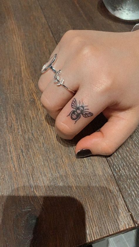 Bee Tattoo Finger Ideas, Bee On Finger Tattoo, Honey Bee Hand Tattoo, Hand Bee Tattoo, Cowrie Shell Tattoo Design, Finger Tattoos Bee, Small Floral Tattoo Designs For Women, Bumble Bee Finger Tattoo, Finger Bee Tattoo